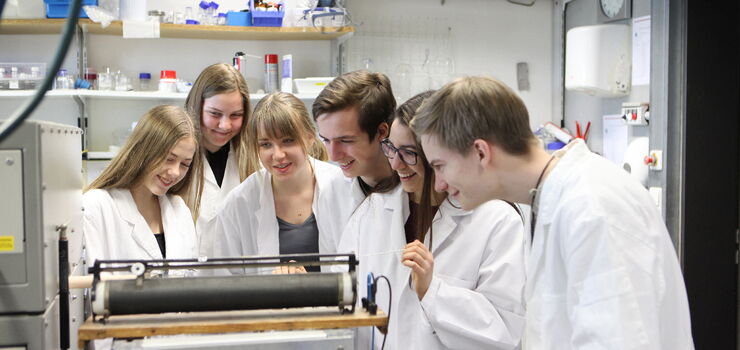 Teilnehmende der Schule 3.0 betrachten ein Experiment